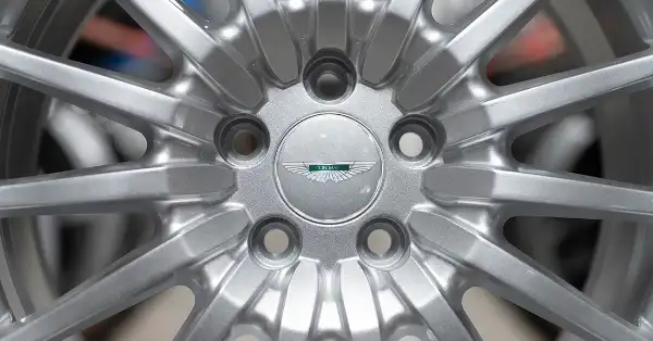 Close-up of 16-spoke Aston Martin DB9 original wheel with centre cap.